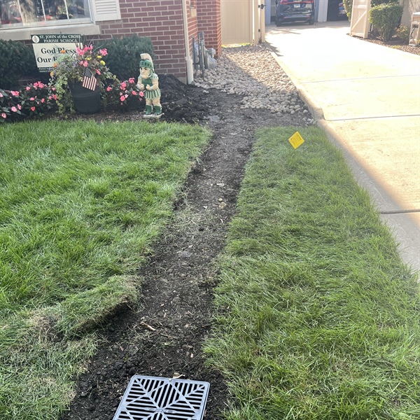 Backfilled yard drainage trench and catch basin at a Western Springs home