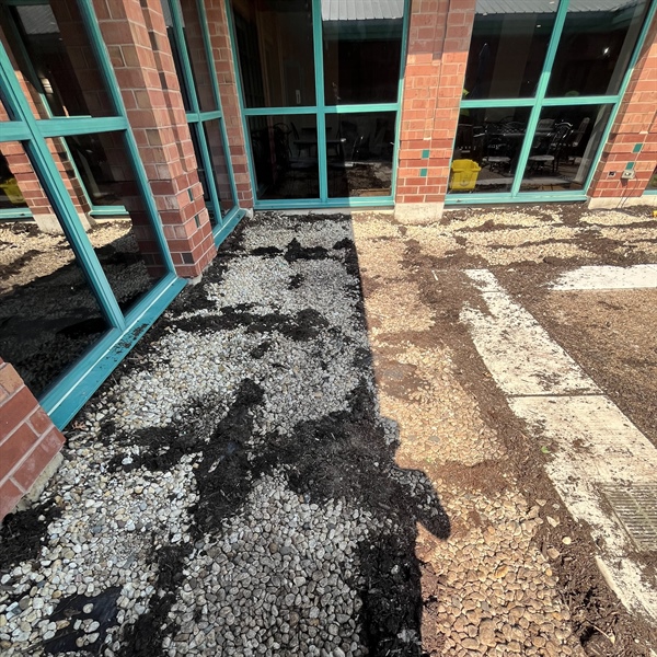 Existing courtyard planting beds with underground rock exposed during landscaping in La Grange, IL