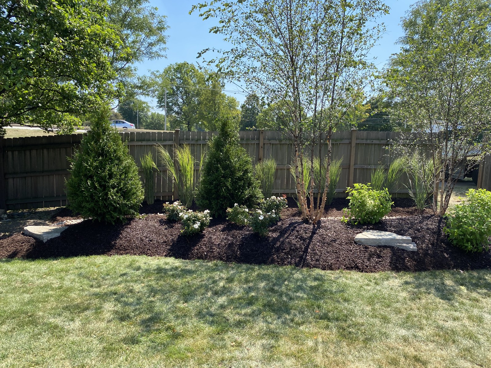 Professionally landscaped garden with mulch beds, ornamental shrubs, and stepping stones in Westmont, IL